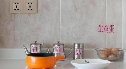 an orange pot on a counter with eggs and a bowl at GreenTree Inn Wuhu Eshan Road University City in Wuhu
