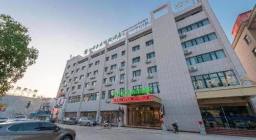 a large white building on a city street at GreenTree Inn Wuhu Eshan Road University City in Wuhu