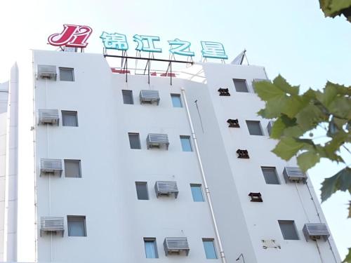 a white building with a sign on it at Jinjiang Inn Qingdao Wuxi Square Nanjing Road Metro Station in Qingdao