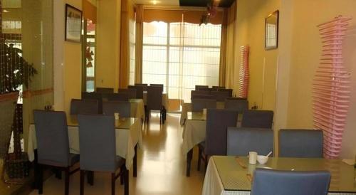 a dining room with tables and chairs and a cafeteria at Jinjiang Inn Qingdao Wuxi Square Nanjing Road Metro Station in Qingdao