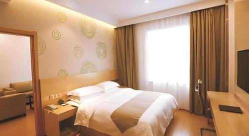 a hotel room with a bed and a television at GreenTree Inn Xi'an Terracotta Warriors Huaqing Pool Metro Station in Xi'an