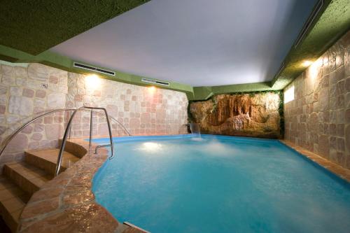 una gran piscina en un edificio de piedra en Hotel Kormorán en Šamorín