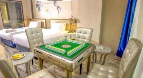 a hotel room with a table and chairs and a bed at Kyriad Marvelous Hotel Xiangyin Bus Station in Xiangyin