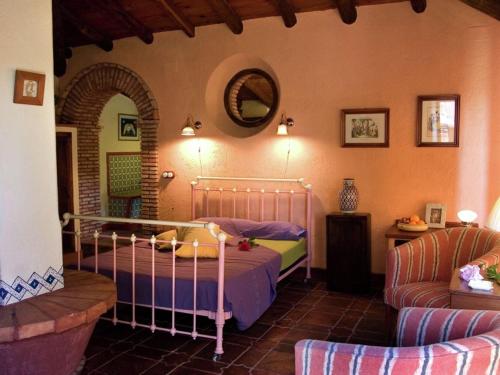a bedroom with a bed and a couch and a mirror at Cottage in Alájar near Gruta de las Maravillas in Alájar