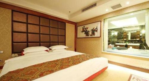 a bedroom with a large bed and a large window at Junyu Grand Hotel Qinhuangdao in Qinhuangdao