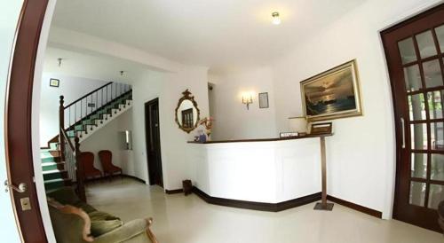 a living room with a staircase and a room with a couch at The MGS Hotel in Elpitiya