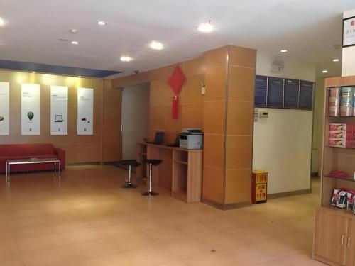 a large room with a red couch in a building at 7 Days Inn Tianjin Binhai New District Yujiabao Metro Station in Binhai