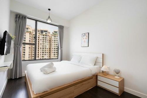 a bedroom with a white bed and a large window at Rivergate Residence Central in Ho Chi Minh City