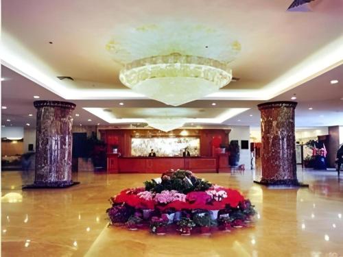 a large lobby with a flower arrangement on the floor at Datong Tiangui International Hotel in Datong
