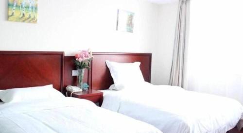 two beds sitting next to each other in a bedroom at GreenTree Inn Hefei Huangshan Road Daxidi 1912 Express Hotel in Hefei