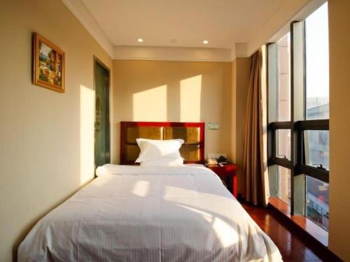 a bedroom with a white bed and a window at GreenTree Inn Hefei Huangshan Road Daxidi 1912 Express Hotel in Hefei