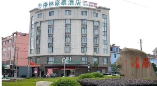 a building with a sign on top of it at GreenTree Inn Jiaxing Tongxiang Tudian Express Hotel in Jiaxing