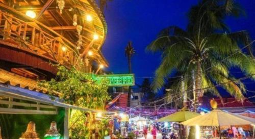a market with palm trees and lights at night at Green Ocean Koh Rong in Koh Rong Island