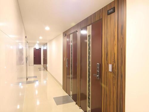 a hallway with wooden doors in a building at Sea View Hotel in Jeju
