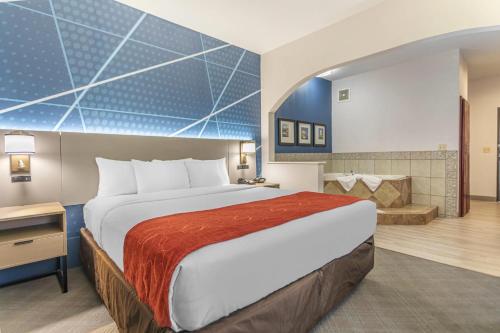 a hotel room with a large bed and a bathroom at Comfort Suites Downtown Sacramento in Sacramento