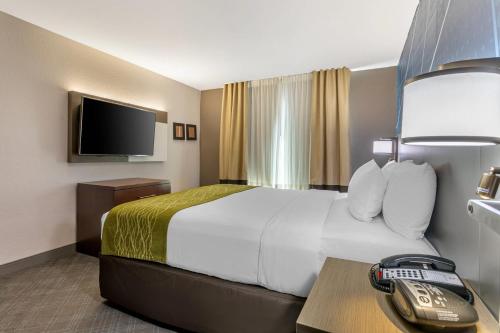 a hotel room with a bed and a telephone at Comfort Suites Downtown Sacramento in Sacramento