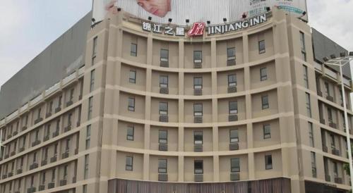 a building with a billboard on the top of it at Jinjiang Inn Linyi Jinqueshan Road Branch in Linyi