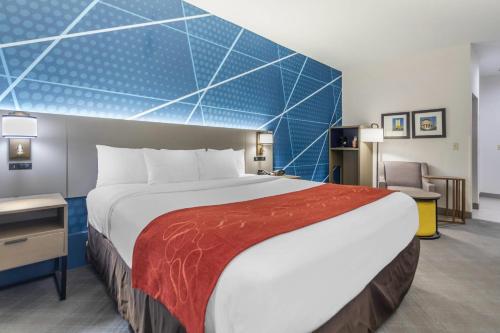 a hotel room with a large bed and a chair at Comfort Suites Downtown Sacramento in Sacramento