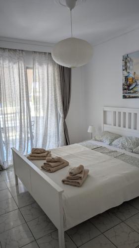 a white bedroom with a bed with towels on it at Apartment 211 in Neoi Epivates