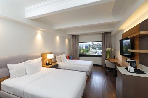 a hotel room with two beds and a television at Clarion Hotel Real Tegucigalpa in Tegucigalpa