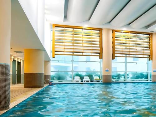 a swimming pool in a building with a large window at Holiday Inn Hotel & Suites Jiaxing Hangzhou Bay By IHG in Jiaxing