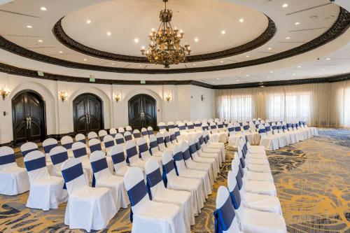 a banquet hall with white chairs and a chandelier at Clarion Hotel Real Tegucigalpa in Tegucigalpa