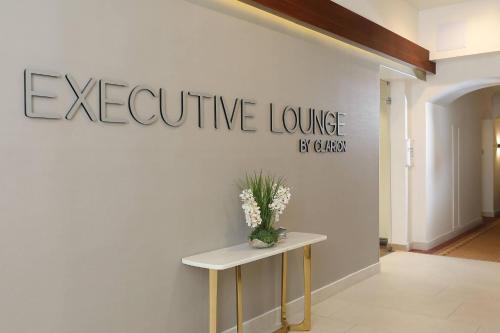 a sign on a wall with a table and flowers at Clarion Hotel Real Tegucigalpa in Tegucigalpa