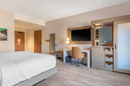 a bedroom with a bed and a desk with a computer at Cambria Hotel Lake Placid - Lakeside Resort in Lake Placid