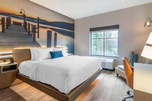 a bedroom with a large bed and a staircase at Cambria Hotel Lake Placid - Lakeside Resort in Lake Placid