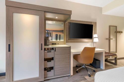 a hotel room with a desk and a television at Cambria Hotel Lake Placid - Lakeside Resort in Lake Placid