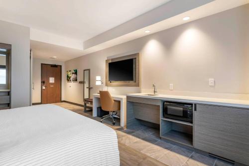 a hotel room with a bed and a sink at Cambria Hotel Lake Placid - Lakeside Resort in Lake Placid