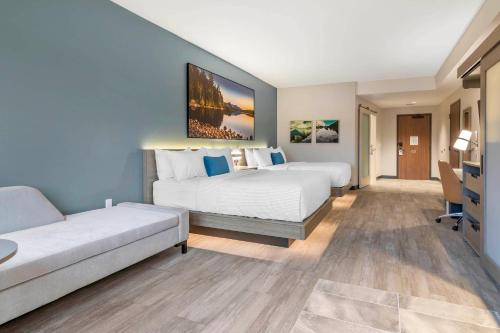 a hotel room with two beds and a couch at Cambria Hotel Lake Placid - Lakeside Resort in Lake Placid