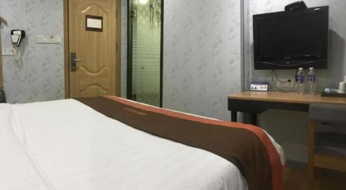 a bedroom with a bed and a desk and a television at Jun Hotel Jiangsu Nanjing Gulou District Gupinggang in Nanjing
