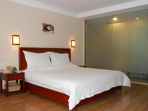 a bedroom with a large white bed and a table at GreenTree Inn Nanning Langdong Hotel in Nanning