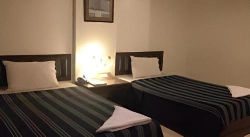 two beds sitting next to each other in a room at Senesouk Hotel in Vientiane