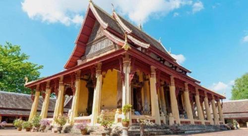 a building with a roof with flowers in front of it at Senesouk Hotel in Vientiane