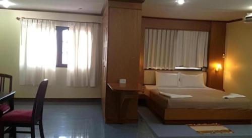 a bedroom with a bed and a desk and a window at Senesouk Hotel in Vientiane
