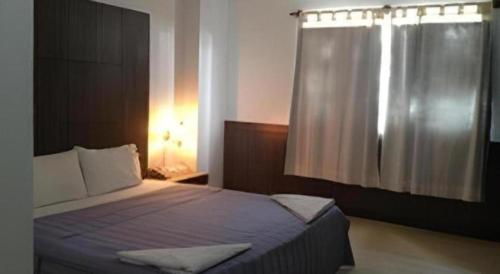 a bedroom with a large bed with a window at Senesouk Hotel in Vientiane