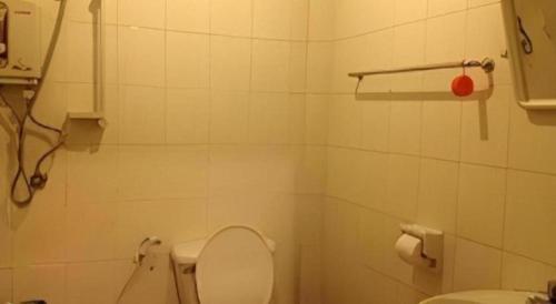 a white bathroom with a toilet and a sink at Senesouk Hotel in Vientiane