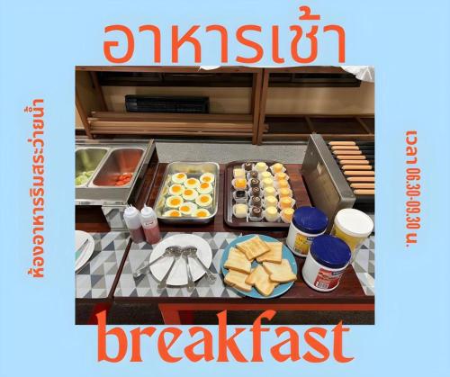 a breakfast table with food on top of it at Hihotel Saraburi in Sara Buri