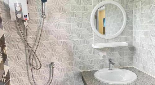 a bathroom with a shower and a sink and a mirror at Hihotel Saraburi in Sara Buri