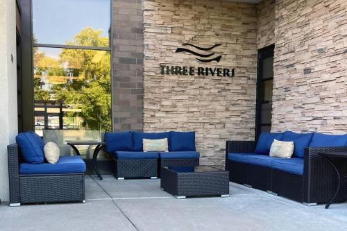 a patio with blue chairs and a sign on a brick wall at Radisson Hotel La Crosse in La Crosse