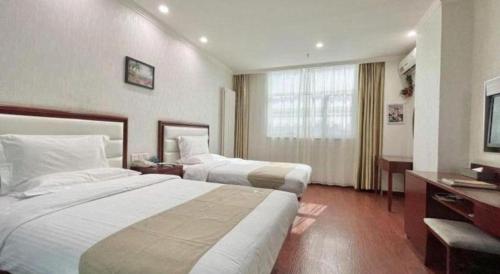 a hotel room with two beds and a television at GreenTree Inn Yinchuan Pedestrian Street East Liqun Street Express Hotel in Yinchuan