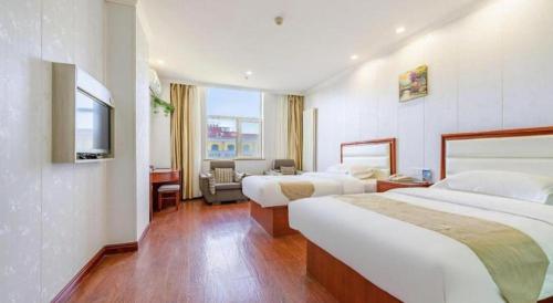a hotel room with two beds and a television at GreenTree Inn Yinchuan Pedestrian Street East Liqun Street Express Hotel in Yinchuan