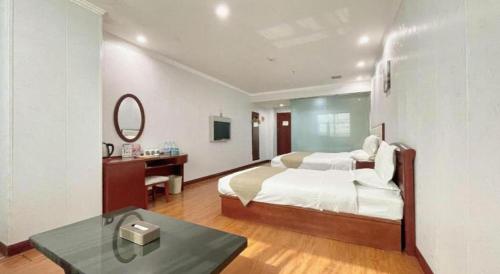 a bedroom with a bed and a desk and a mirror at GreenTree Inn Yinchuan Pedestrian Street East Liqun Street Express Hotel in Yinchuan