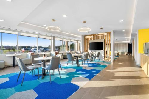 a dining room with tables and chairs and a flat screen tv at Microtel Inn & Suites by Wyndham Prattville Montgomery in Prattville