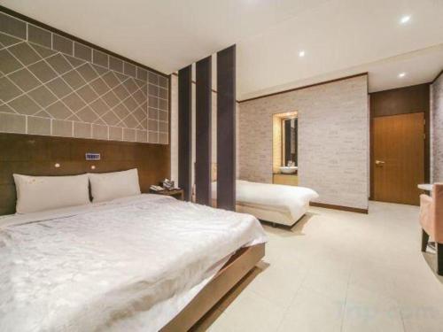 a bedroom with a large white bed and two beds sidx sidx sidx sidx at Nostalgia Hotel in Paju