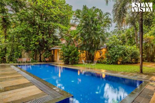 a villa with a swimming pool in a resort at StayVista at Villa Nimaya with Lawn & Pool in Saligao
