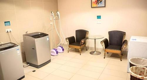 a waiting room with chairs and a table and a machine at City Comfort Inn Beihai RT-Mart High Speed Railway Station in Beihai