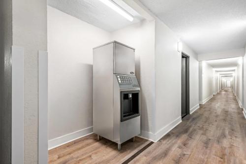 an empty hallway with a refrigerator in a white room at Quality Inn in West Haven